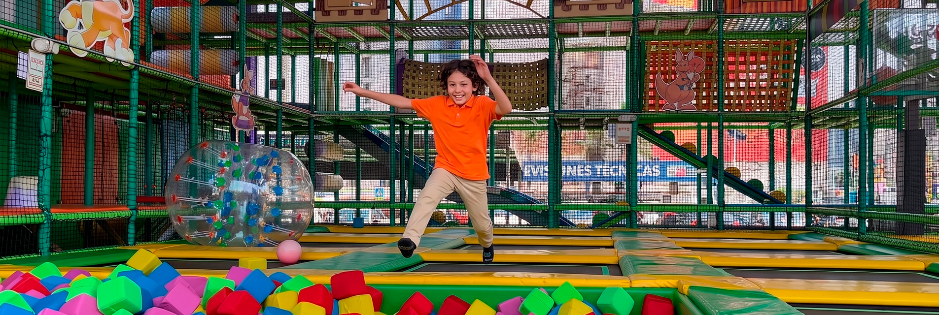 Grupo de niños disfrutando en piscina de pelotas gigante, ven a jugar a Jump Spot en tu ciudad